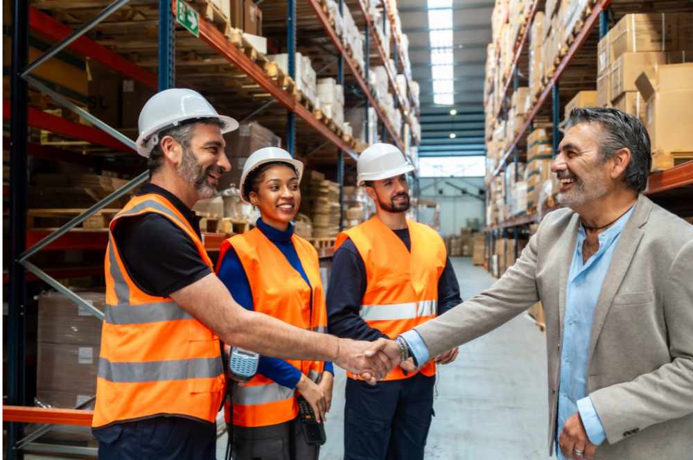Employer handshaking with warehouse employees